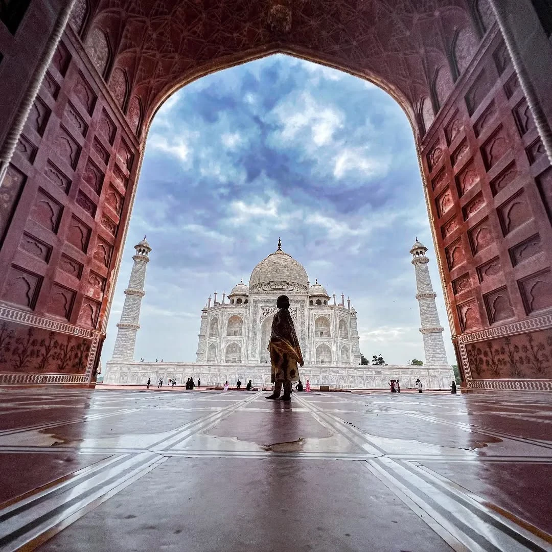 A white marble monument framed by a sandstone arch.