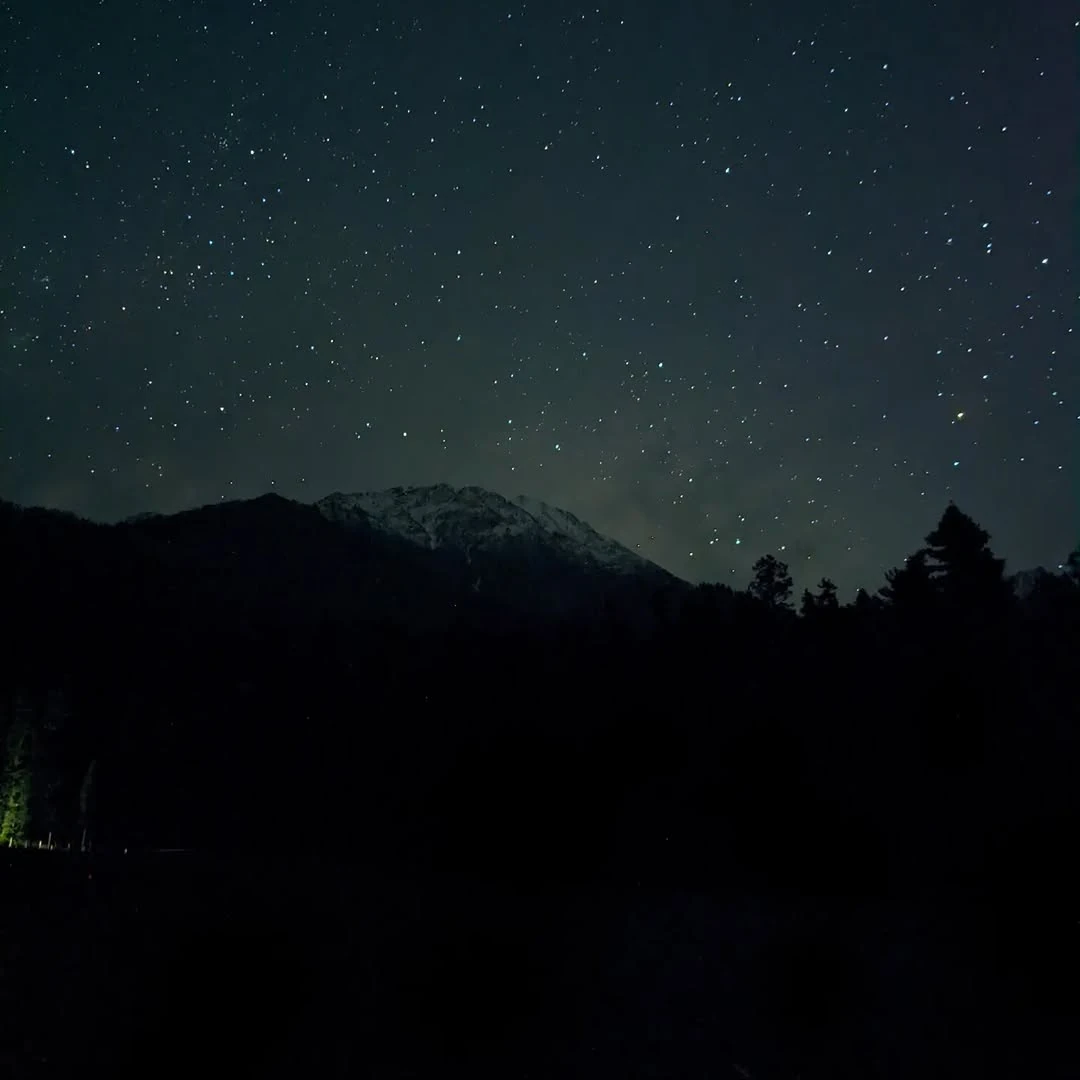 Stars over a dark mountain ridge.